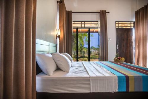 卡特勒格默Wadula Safari - Yala的一间卧室设有一张大床和窗户