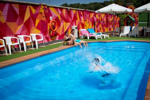 索里亚Hotel Restaurante Cadosa的两个人在游泳池玩耍