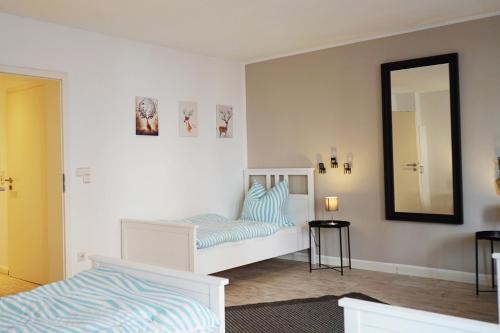 门兴格拉德巴赫Work & Stay Apartment的卧室配有白色的床和镜子