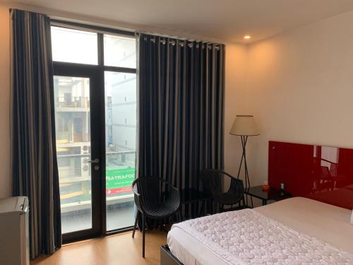 胡志明市Gia Huyền Hotel的酒店客房设有一张床和一个大窗户