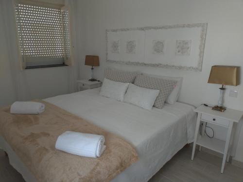 奥良Casa da avó Lu的白色卧室配有一张带白色床单和枕头的大床