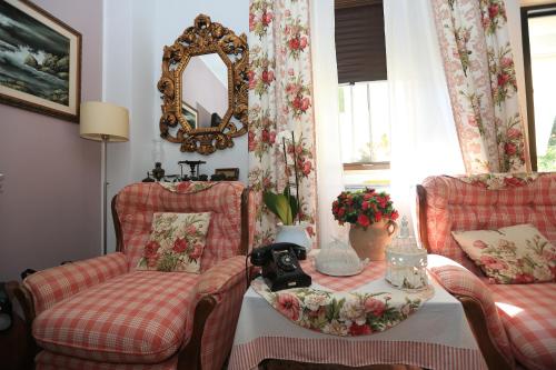 葛伦坦马勒B&B La casa di g.g.的客厅配有两把椅子、一张桌子和镜子