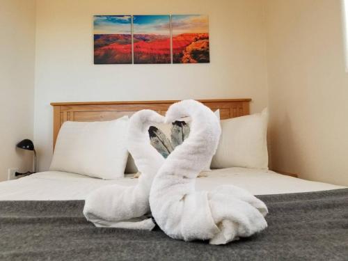 瓦莱072A Affordable Getaway near South Rim Sleeps 4- No Kitchenette的两只天鹅用毛巾制成,坐在床上