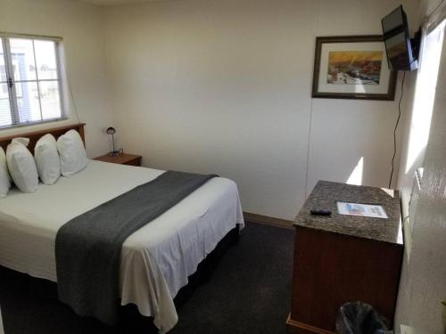 瓦莱068C Cozy Studio Grand Canyon South Rim Sleeps-2的酒店客房配有一张床铺和一张桌子。