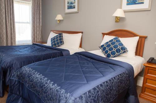 阿比菲尔雷恩斯酒店的两张位于酒店客房的床,配有蓝色和白色的床单