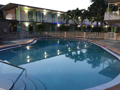 克利尔沃特Tropical Inn & Suites, downtown clearwater的晚上在酒店前面的一个大型游泳池