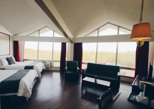 蒙克顿蒙克顿酒店的酒店客房带两张床、椅子和窗户
