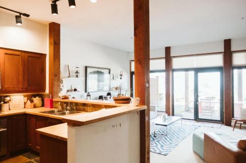 尤克卢利特Pacific Soul Eco-Luxe Vacation Home的一个带木制橱柜和大窗户的厨房