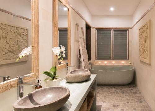 乌鲁瓦图宾艮阿罗哈海滩之家别墅的浴室配有大浴缸、盥洗盆和浴缸。