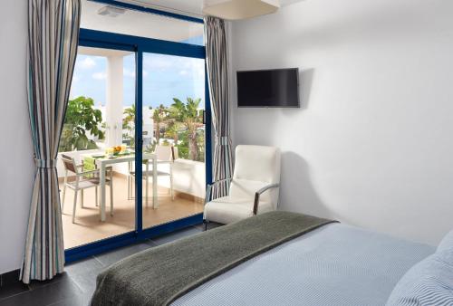 普拉亚布兰卡Villas de la Marina的一间卧室配有一张床,阳台配有桌子