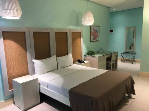 独鲁万洛伦扎酒店的一间卧室配有一张大床和一张书桌