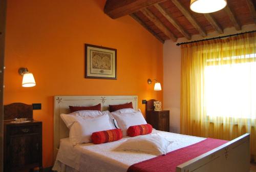 卡希纳Il Cantuccio的一间卧室配有红色和白色枕头的床
