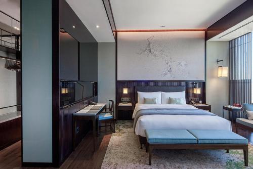 北京诺金酒店的酒店客房带一张床、一张书桌和一面镜子