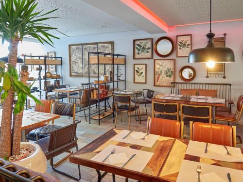 阿尔库迪亚港BelleVue Club的一间在房间内配有桌椅的餐厅