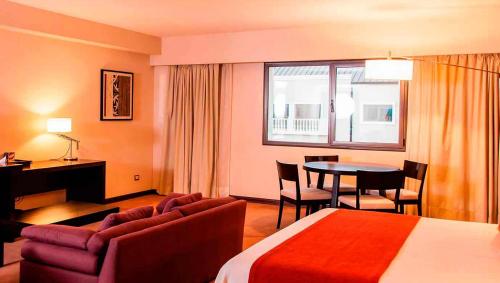 福尔摩沙Howard Johnson Hotel & Casino的酒店客房带一张床、一张桌子和椅子