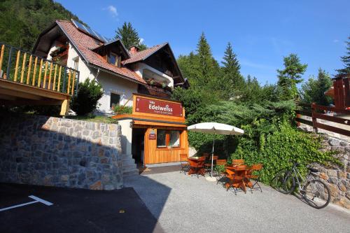 克拉尼斯卡戈拉Vila Edelweiss Rooms&App Kranjska Gora的一座配有桌椅和遮阳伞的建筑