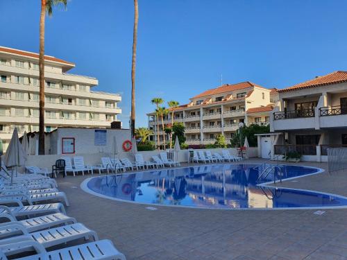 阿罗纳Spectacular Ocean Apartment with AirCon in Golden Mile of Las Americas的一个带白色躺椅的游泳池和一间酒店