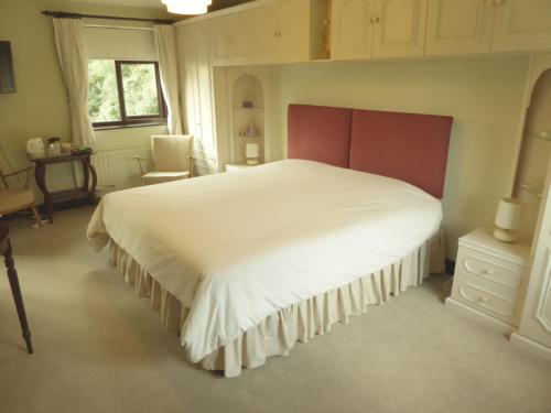 EdlingtonAt Last Bed & Breakfast的卧室配有一张白色大床和一把椅子