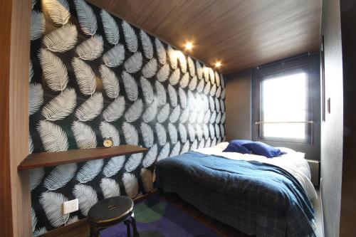 东京s-rea TOKYO301的卧室设有1张床铺和1把椅子,墙壁上设有1张