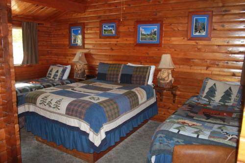布里奇波特弗吉尼亚河居留地酒店的小木屋内一间卧室,配有两张床