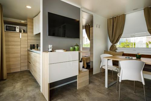 诺维格勒伊斯特拉Amber Sea Luxury Village Mobile Homes的小厨房以及带桌椅的用餐室。