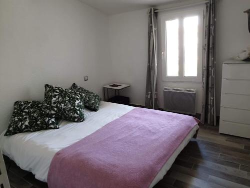 勒沙托多莱龙Ma Maison的卧室配有带枕头的白色床和窗户。