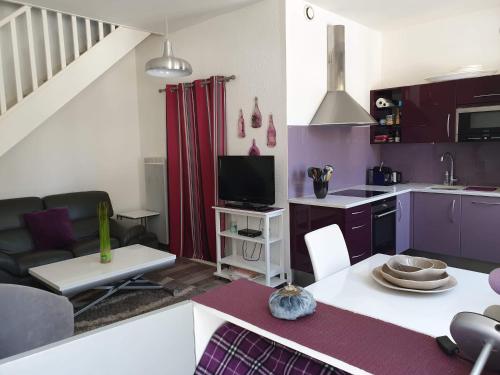 勒沙托多莱龙Ma Maison的厨房以及铺有紫色和白色的起居
