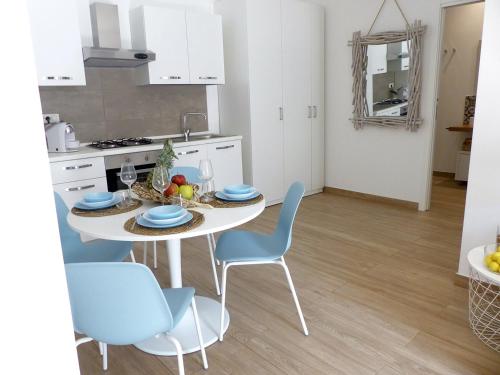 锡拉库扎Nesh House的厨房配有白色的桌子和蓝色的椅子