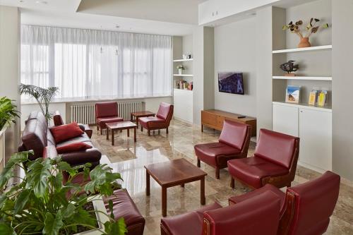 切塞纳蒂科Hotel Dolores的一间带红色椅子的客厅和一间候机室