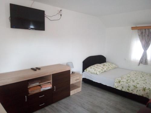 巴尼亚卢卡Apartmani "Babići"的卧室配有一张床,墙上配有电视。