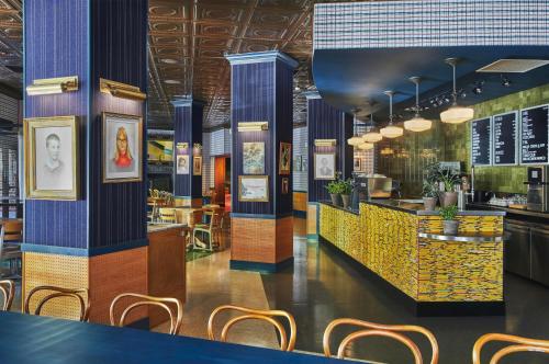 普罗维登斯Graduate Providence的餐厅设有蓝色和黄色的柱子和椅子