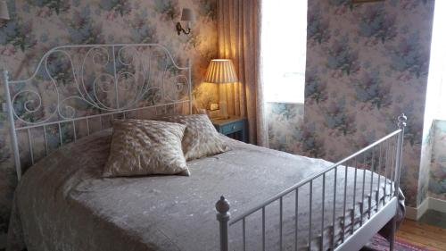 塔登La Petite Maison Bleue的一间卧室配有一张带金属床头板的床