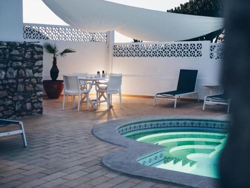 卡武埃鲁维温达布里托酒店的一个带桌椅的庭院和一个游泳池