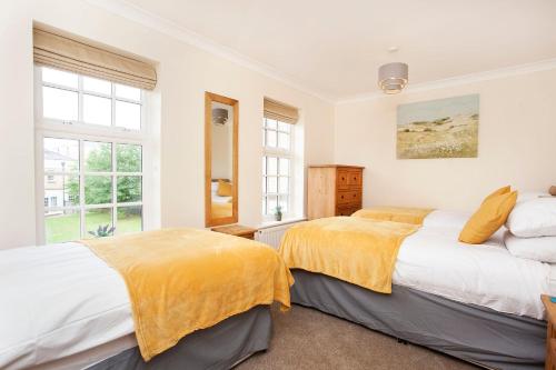 约克Thomas, off Leeman Road, Sleeps 9的卧室设有两张床,拥有白色的墙壁和窗户。