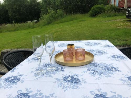 VikAuregarden - a rustique oasis just a blink away from town centre的一张桌子,上面有两杯酒杯和盘子