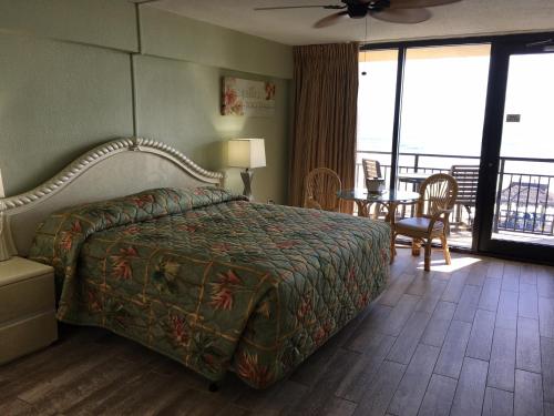代托纳海滩代托纳海滩夏威夷酒店的酒店客房带一张床、一张桌子和椅子