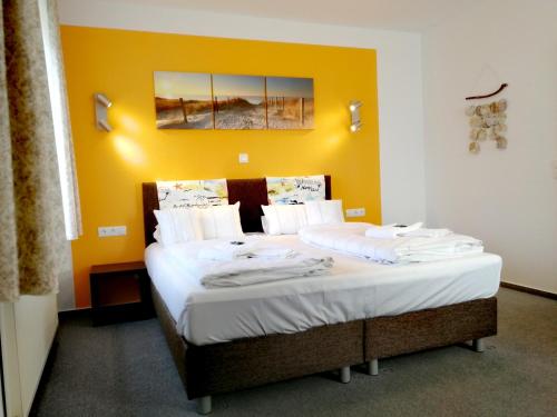 瓦尔斯罗德Hotel & Gasthaus Zum Domkreuger的黄色墙的房间里一张床位