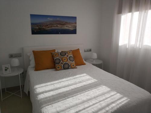 洛斯克里斯蒂亚诺斯Oliva Home的一间卧室配有带橙色枕头的床