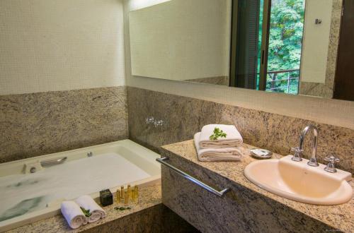圣若昂-德雷园山酒店与高尔夫度假村的浴室配有盥洗盆和浴缸。