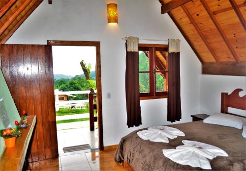 蒙特韦尔迪Chalés Fazenda Vale da Mata的一间卧室设有一张床和一个大窗户