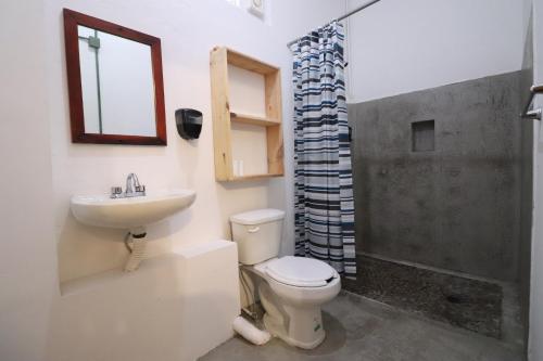 普拉亚卡门Wabi Hostel的浴室配有卫生间、盥洗盆和淋浴。