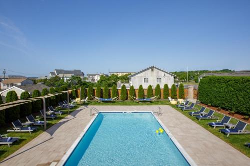 蒙托克蒙托克阿奎丽娜汽车旅馆的一个带躺椅的游泳池以及一座房子