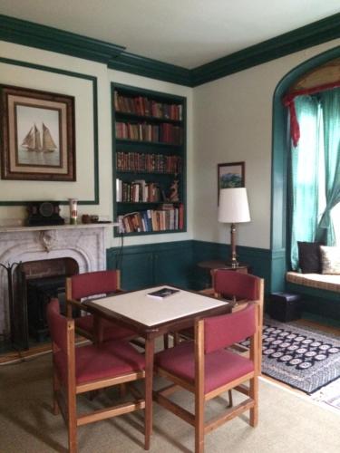 拉特兰Antique Mansion B & B的一间带桌椅和壁炉的用餐室