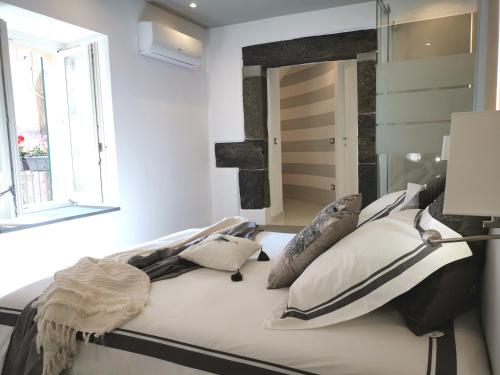 韦尔纳扎Vernazza Luxury Apartment的一间卧室配有带枕头和镜子的床
