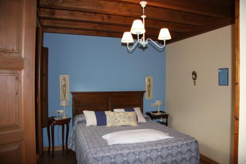 努埃瓦德兰斯Hotel rural La Llastra的一间卧室配有一张蓝色墙壁的床