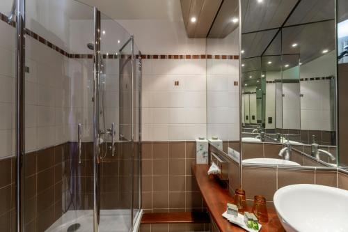 萨莱Le Bailliage Hôtel & Spa的一间带两个水槽和玻璃淋浴间的浴室