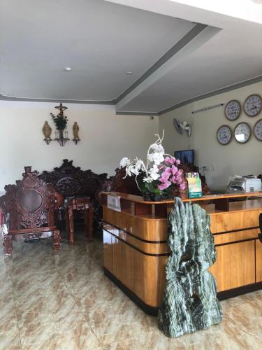 邦美蜀Kim Ngân Hotel Buôn Ma Thuột的一间有鲜花的柜台的房间