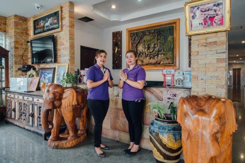 华欣Iyara Hua Hin Lodge的两个女人站在一间有雕像的商店前