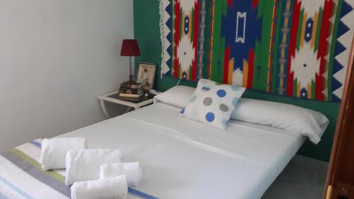 特拉武科新镇Cortijo la Dehesa del Trabuco的卧室配有白色床和色彩缤纷的墙壁