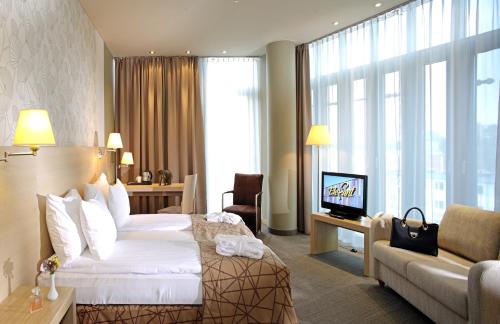 里加Rixwell Elefant Hotel的酒店客房配有床、沙发和电视。